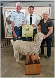 Dave Norton, Judge Allen Mesick and Ellie Gregory with Nina, Grand Champ-ion White Angora Doe  Billy Goat Mountain Ranch. Photo: Lynne Schlosser